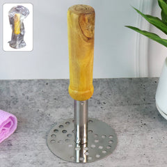 Stainless steel potato masher with wooden handle on kitchen counter