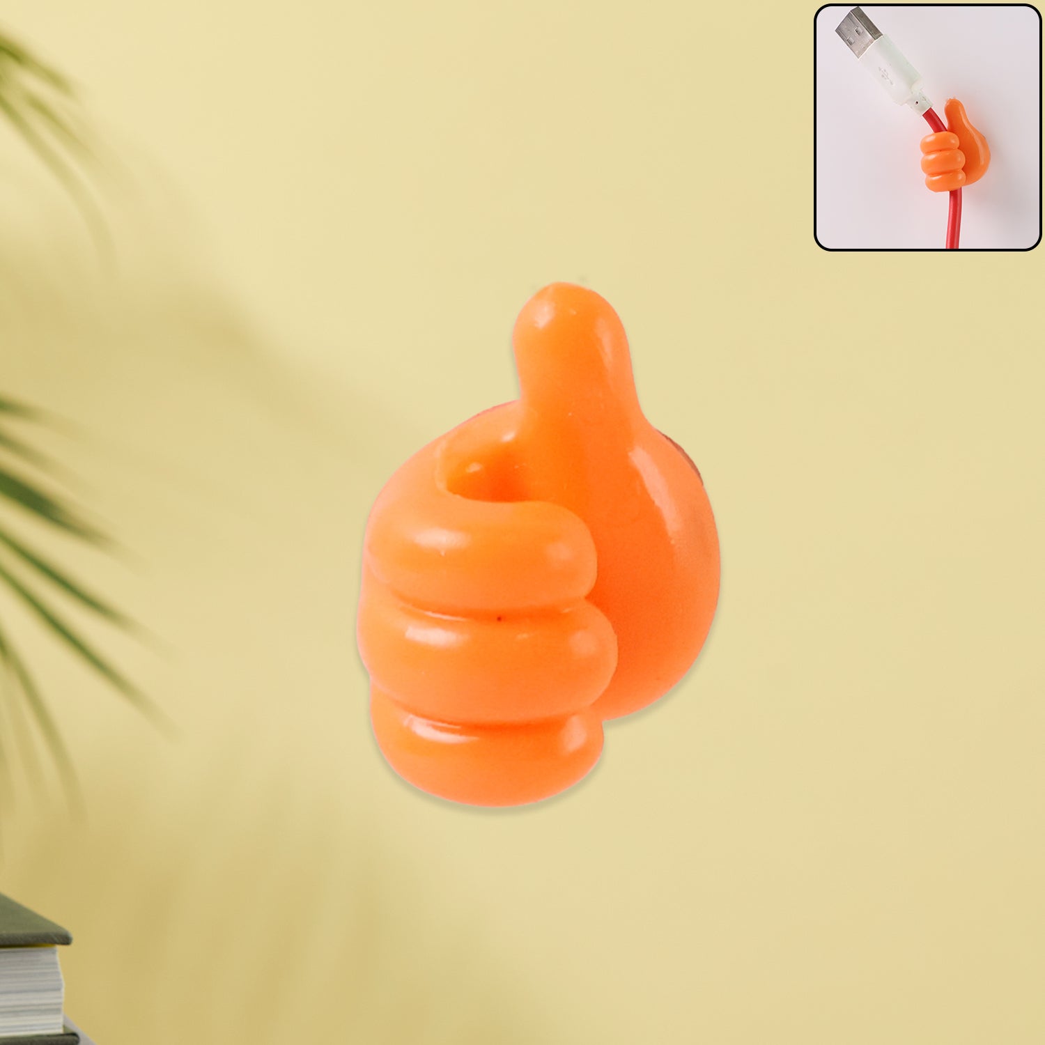 Orange hand-shaped wall clip hanger holding cables
