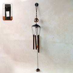 Metal wind chime with Om symbol hanging outdoors