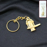 Golden Shivling metal keychain on white background