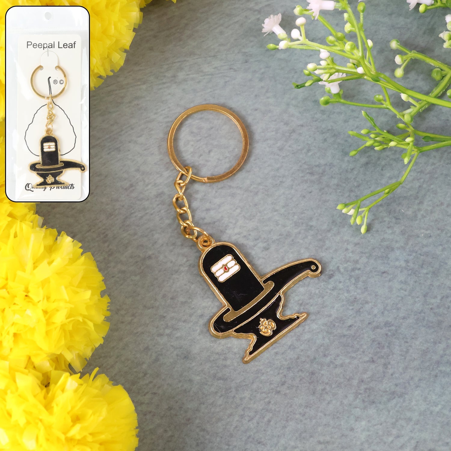 Golden Shivling metal keychain on a plain background