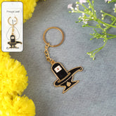 Golden Shivling metal keychain on a plain background