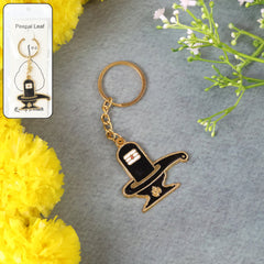 Golden Shivling metal keychain on a plain background