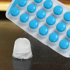 Person pushing out round mini ice cubes from silicone tray