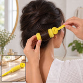 A woman with dark hair uses a bright yellow foam roller to curl a section of her hair.