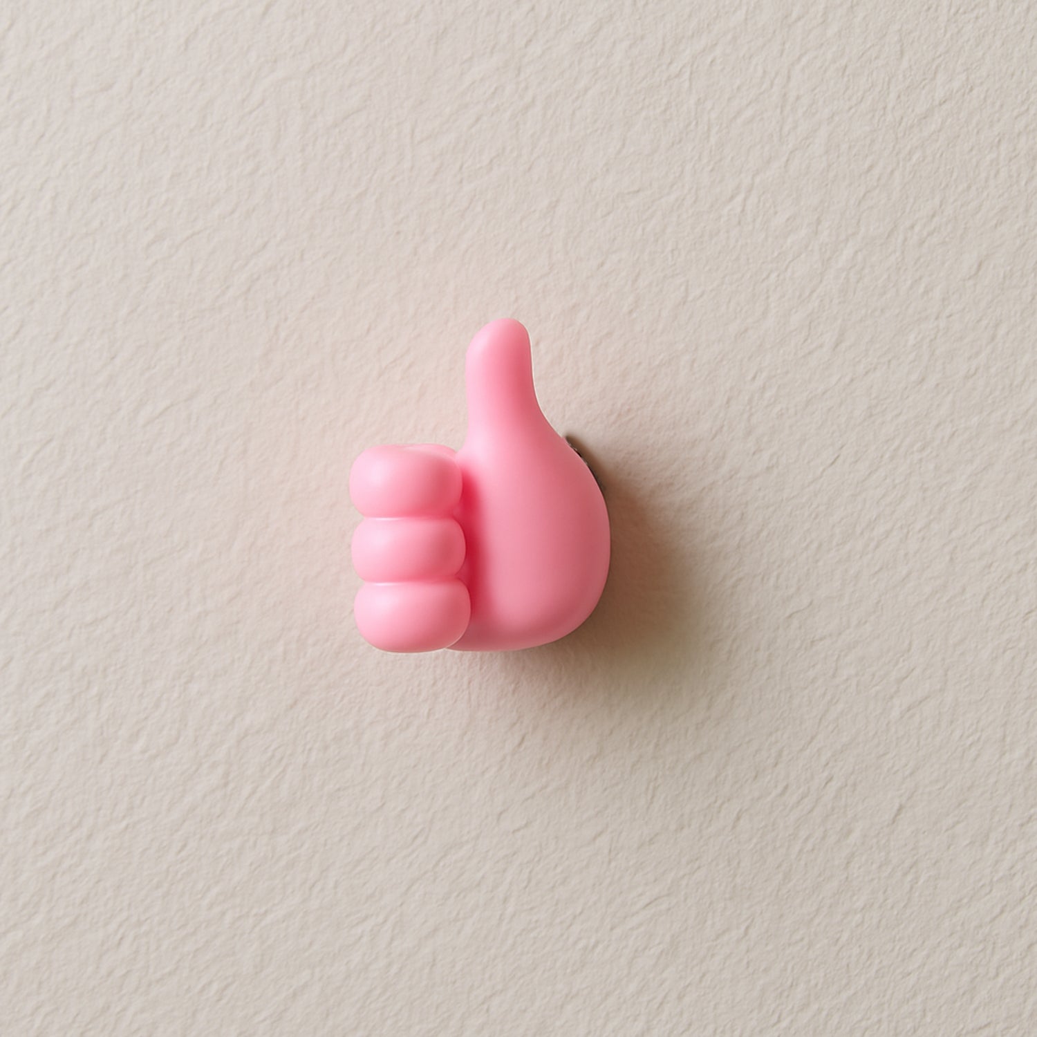 Pink hand-shaped wall clip holder on white background