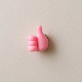 Pink hand-shaped wall clip holder on white background