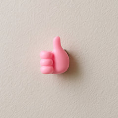 Pink hand-shaped wall clip holder on white background