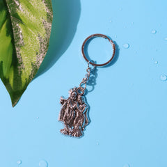 Radha Krishna metal keychain, side view showing thickness
