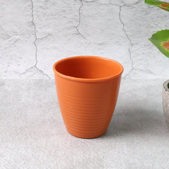 Plastic small drinking glass filled with tea on a table