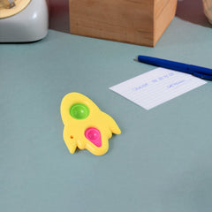 Rocket Fidget Dimple Keychain Toy attached to a backpack, illustrating portability