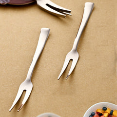 Close-up of stainless steel fruit fork gripping fruit