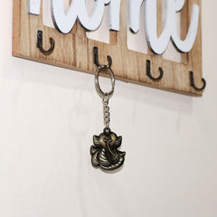 Ganesh Face antique black metal keychain held in hand