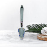 Triangular sponge brush cleaning a kitchen sink with long handle