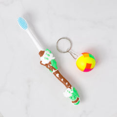 Child's hand holding a colorful kids toothbrush
