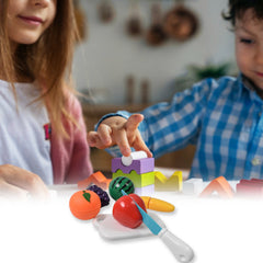 Child's hands slicing toy watermelon on a cutting board
