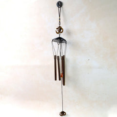 Metal Om symbol wind chime hanging on a porch