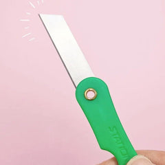 Hand holding a mini paper cutter knife
