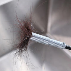 Removing hair clog from sink pipe with spring tool