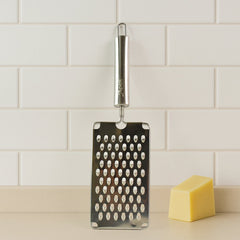 Flat handheld vegetable grater in use for vegetable preparation