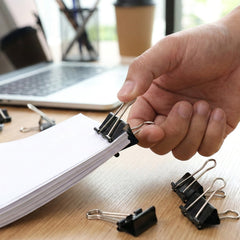 Black binder clips holding documents