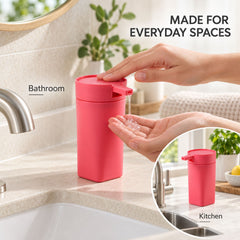 A pink rectangular dispenser is shown in a bathroom and kitchen setting, with a hand pressing the pump to release liquid.