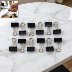 Black metal binder clips piled