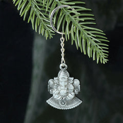 Close-up of Lord Ganesha sitting design on silver keychain