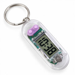 A transparent digital clock keychain with purple buttons and a metal ring, displaying 10:38 on a white surface.