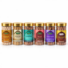 Six clear plastic jars of dhoop sticks with gold lids, each labeled with a distinct fragrance, on a white background.