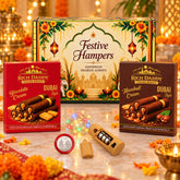 A festive gift hamper with two boxes of wafer rolls, a string of LED lights, a battery pack, and a silver coin, all on a