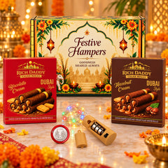 A festive gift hamper with two boxes of wafer rolls, a string of LED lights, a battery pack, and a silver coin, all on a