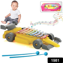 Child playing with car shaped xylophone