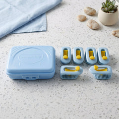A light blue plastic storage case and six blue and yellow plastic clips are arranged on a speckled white countertop next to