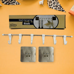 Utensil hanger rail mounted on wall holding kitchen ladles and tools