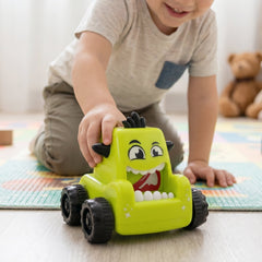 Child playing with a red cartoon monster push back car toy