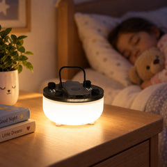 A white night light glows on a wooden nightstand, next to a sleeping child and a teddy bear in a bed.
