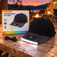 A black baseball cap with an integrated LED light and motion sensor, next to its product box and a USB cable, on a wooden