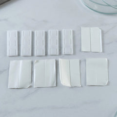 Plastic holder clips with adhesive pads
