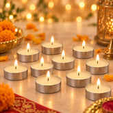 Ten lit tea light candles glow on a decorated surface with blurred background lights.
