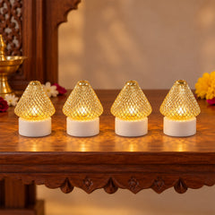 Four golden mesh LED lights with white bases illuminate a wooden table with festive flowers and a brass pot.