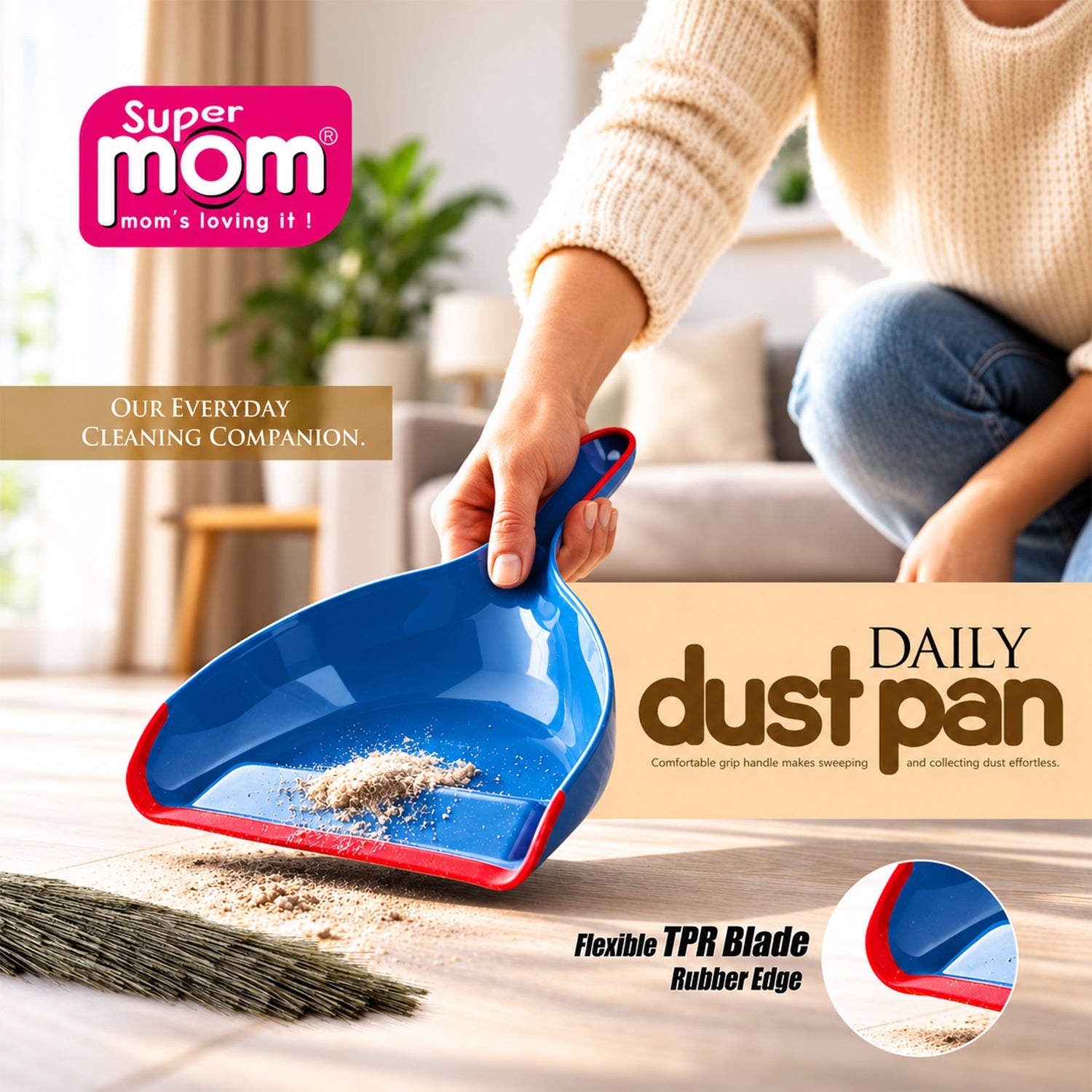 A person holds a blue and red dustpan with collected dirt, next to a broom on a wooden floor.