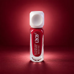 A single bottle of red nail polish with a white cap stands centered against a dark red gradient background.