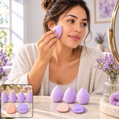 A woman applies makeup with a lavender sponge, with additional sponges and puffs on a marble surface.