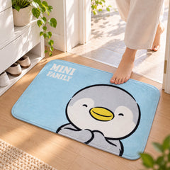 A person steps onto a light blue bath mat featuring a cute grey and white penguin design with yellow beak.