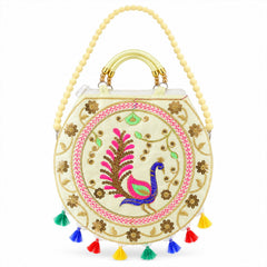 Front view of a cream round bag with vibrant peacock embroidery, gold accents, and a beaded sling strap.
