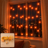Orange LED curtain lights illuminate a window at night, with a coiled set of lights in the corner.