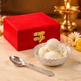 Silver finish floral bowl filled with ice cream scoops, a matching spoon, and a red velvet gift box.