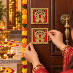 A person adheres a golden Lakshmi Charan sticker to a wooden door, surrounded by marigold garlands and glowing diyas.
