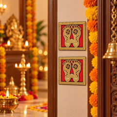 Two golden Lakshmi Charan stickers adorn a light brown door, with a blurred background of a festive interior and lit lamps.